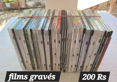 CD collection of recorded films, assorted colors and brands, stacked on a table in Mauritius.