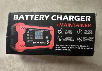 Battery Charger and Maintainer for automotive use, red and black design, digital display, compact size, suitable for winter and summer conditions, with pulse repair and multiple protection features.