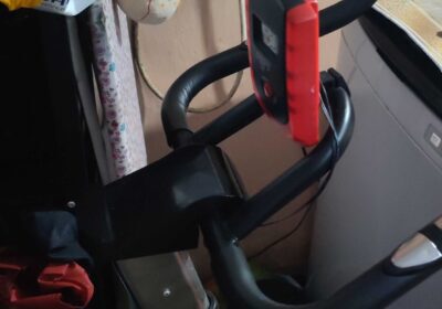 Exercise bike with red and black frame, digital display, and adjustable seat, ideal for home fitness.