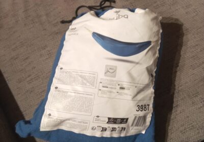 Outdoor blue and white backpack with a curved design, brand logo, and product information. Suitable for travel or daily use.