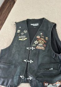 Motorcycle leather vest with patches and badges, black color, for riding enthusiasts.