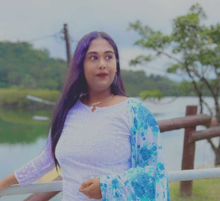 Elegant white and blue dress, long black hair, outdoor scene with trees and water in Mauritius.
