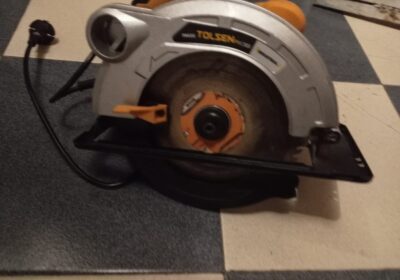 Circular saw power tool, orange and gray, brand TOLSEN, for cutting wood and materials.