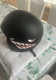 Helmet with a black matte finish and a fierce, cartoonish shark face design, perfect for motorcycle or scooter riders in Mauritius.