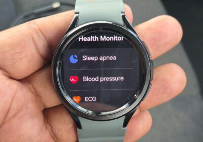 Smartwatch with health monitoring features, black and gray, with orange accents.